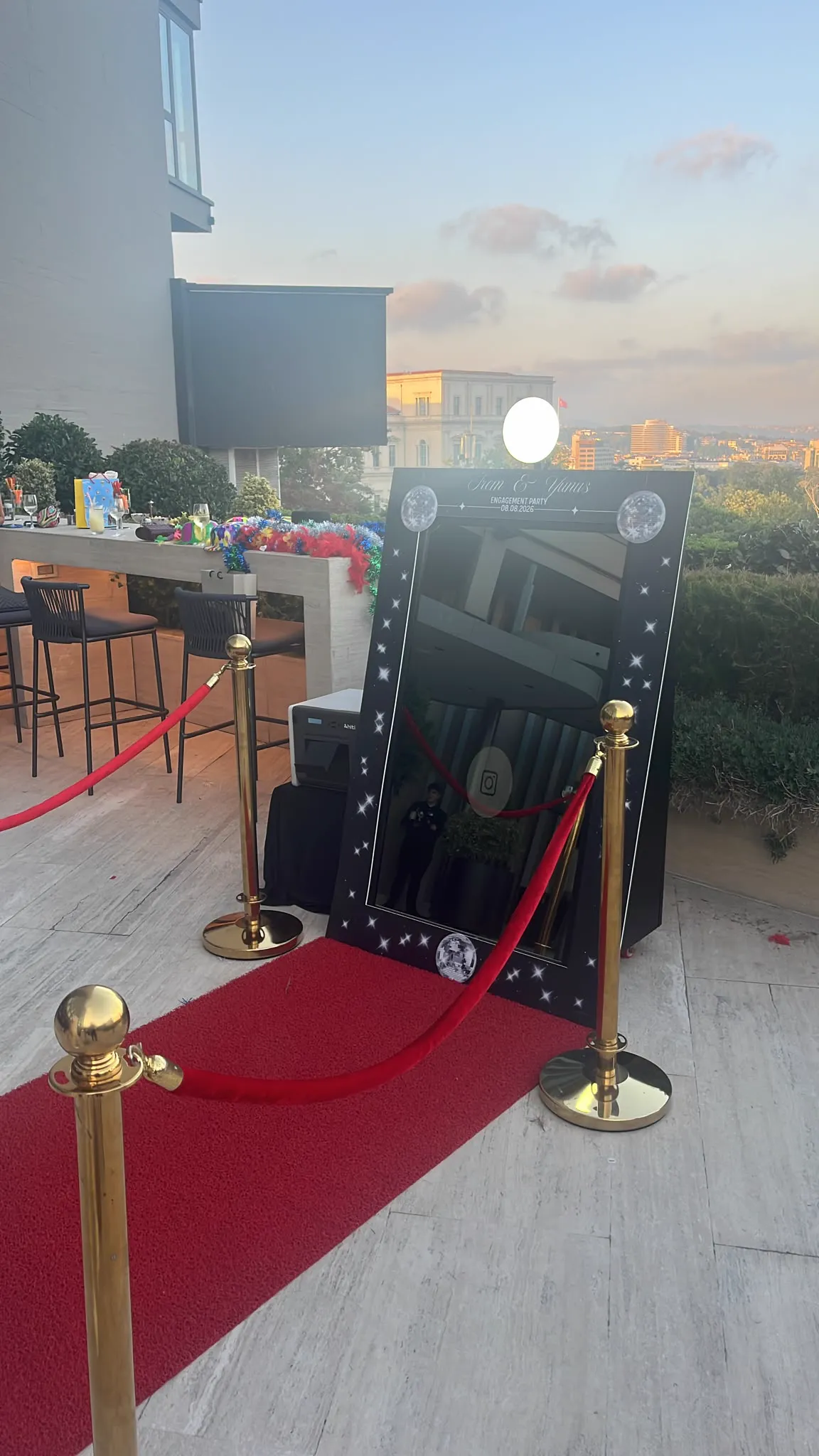Teras davetinde kırmızı halı ve altın bariyerlerle kurulan mirror booth