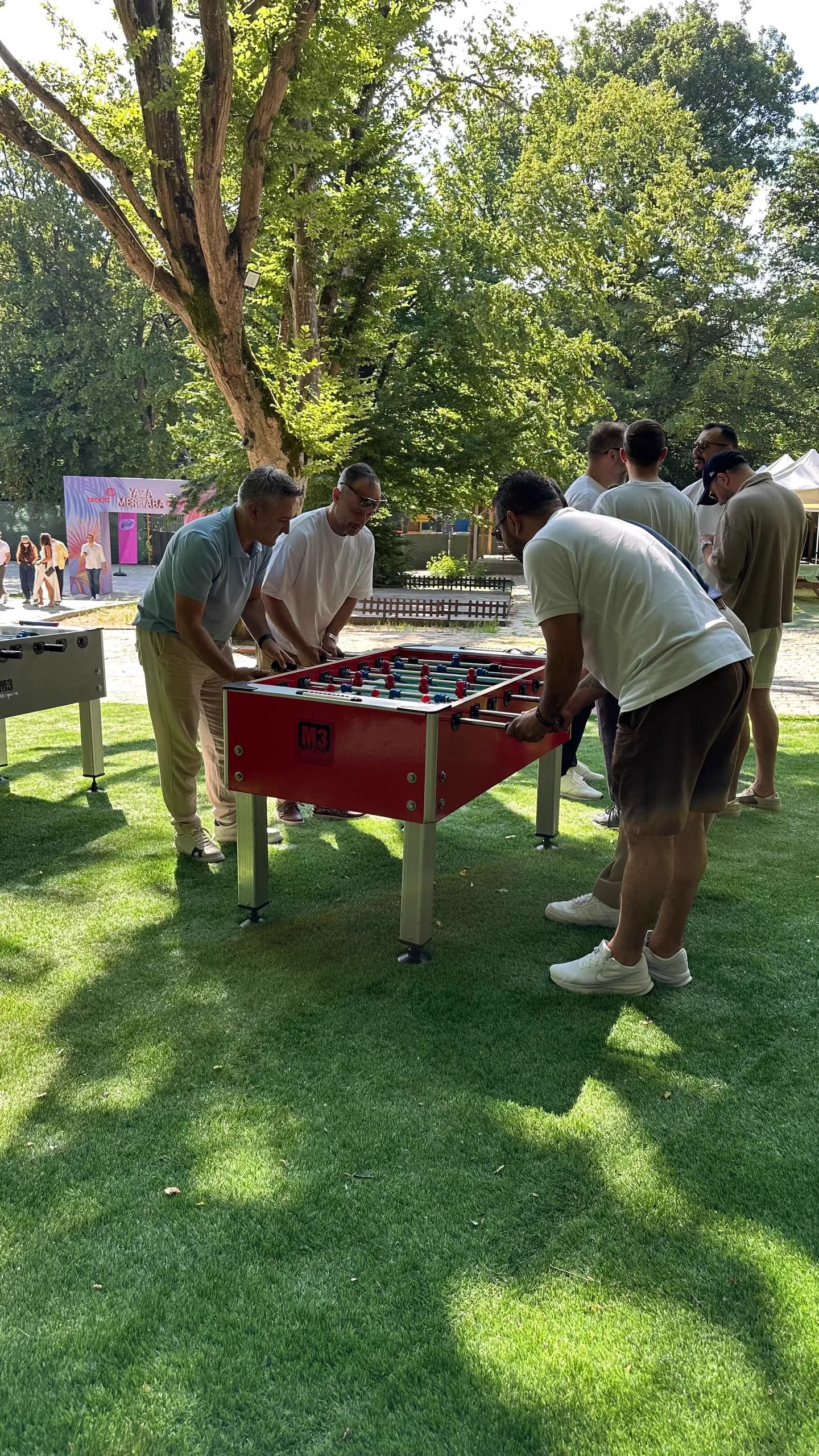 Çim alanda langırt masasında oynayan katılımcılar