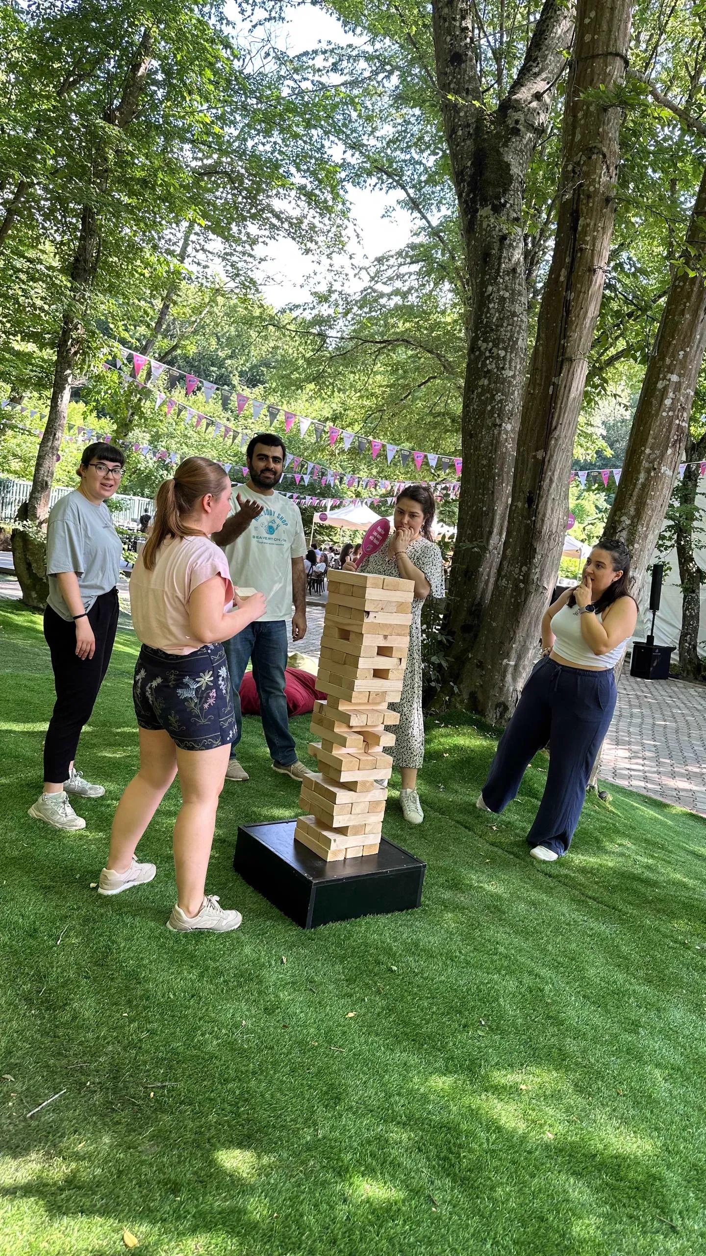 Ağaçların altında dev jenga oynayan katılımcılar